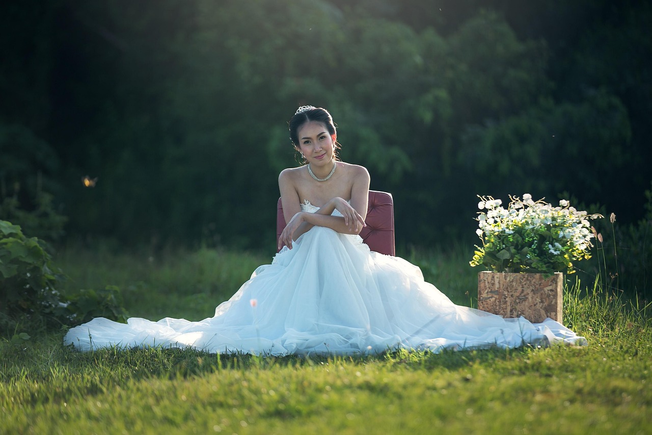 A bride seated on the grass in her dress